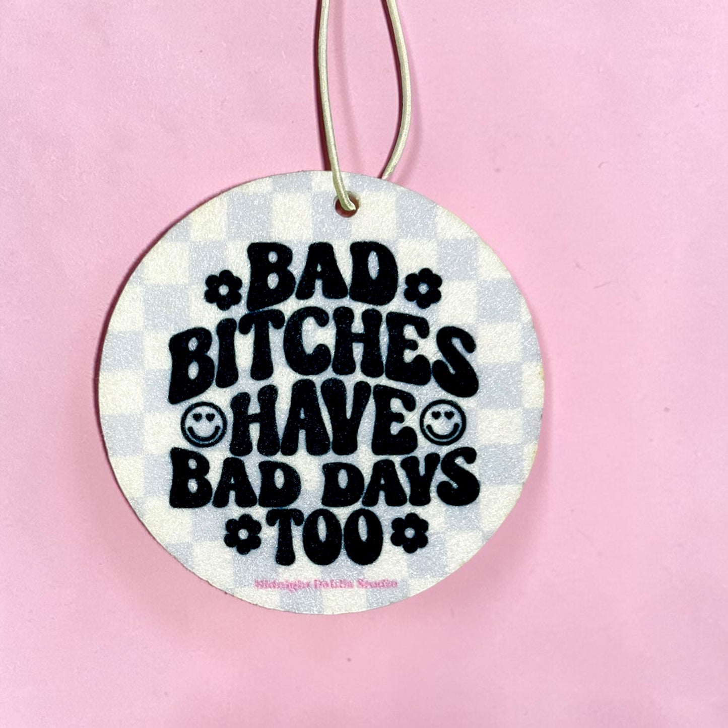 Circular sign with text 'Bad Bitches Have Bad Days Too' on a pink background