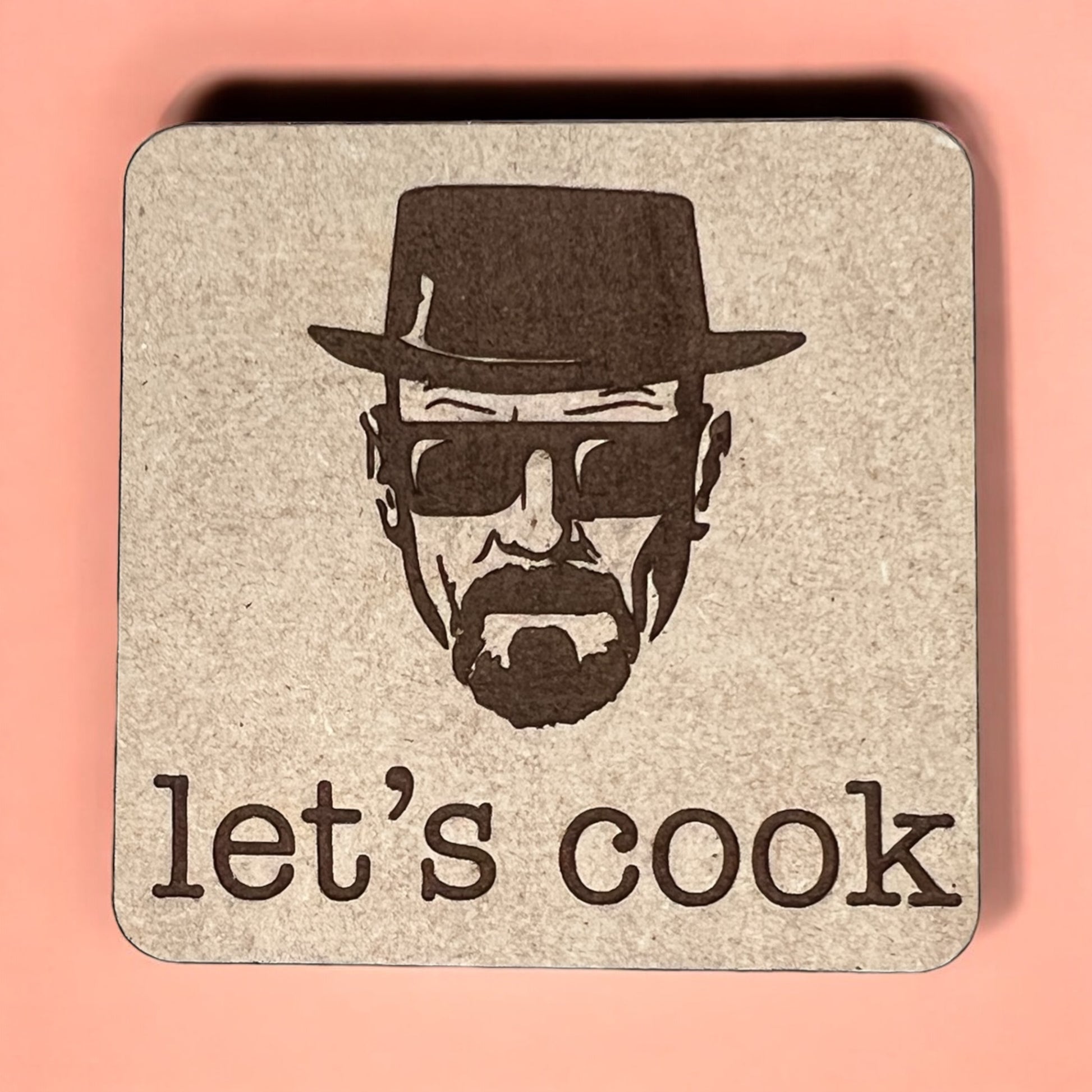 A square magnet with a humorous quote printed on it, placed against a pink background.