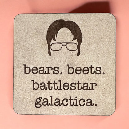 A square magnet with a humorous quote printed on it, placed against a pink background.
