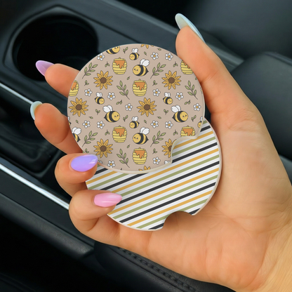Hand holding a car coaster with bee and flower pattern
