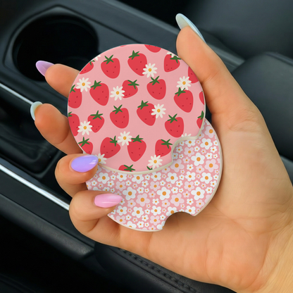 Hand holding a pink car coaster with strawberry pattern