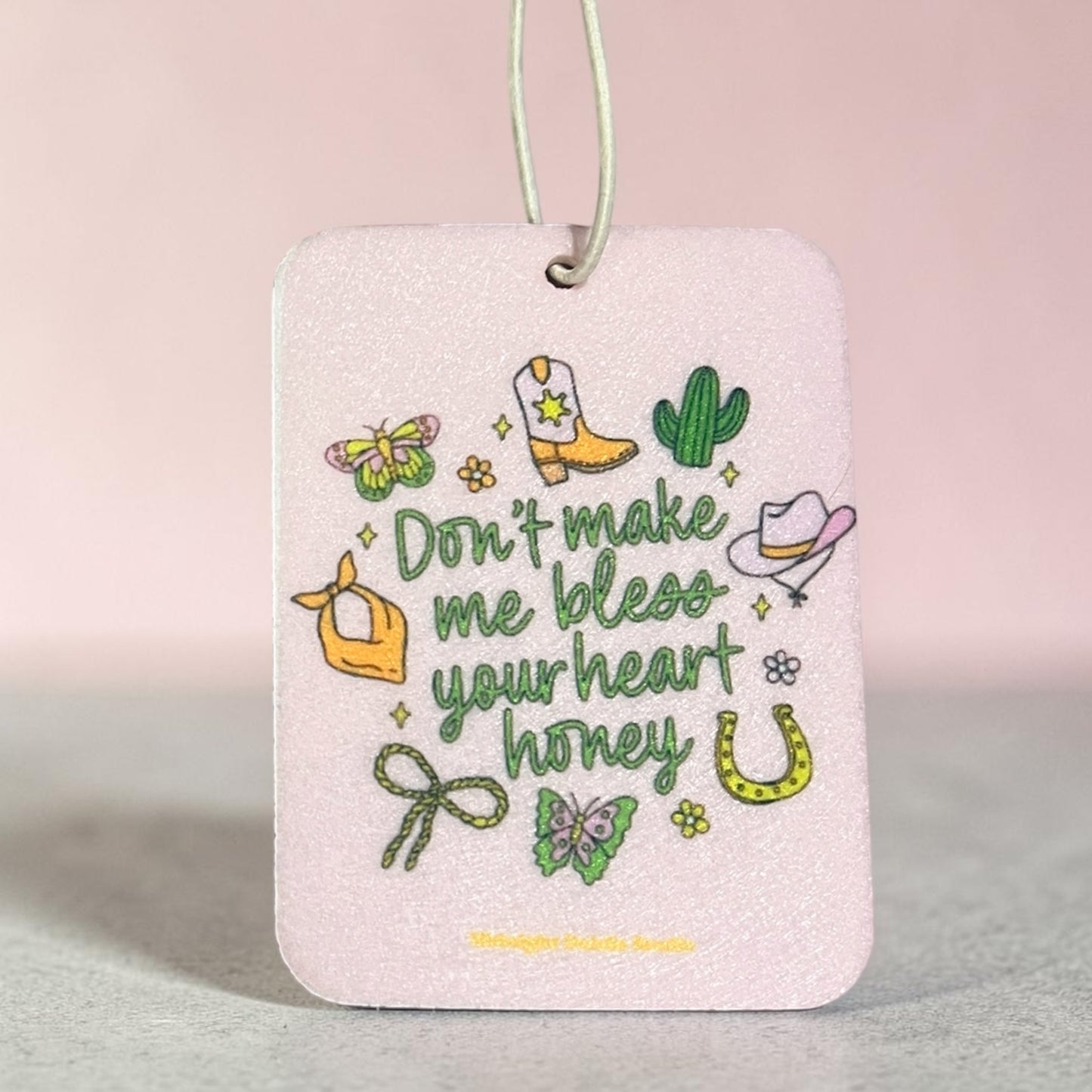 Decorative tag with cowboy-themed illustrations and text on a light pink background