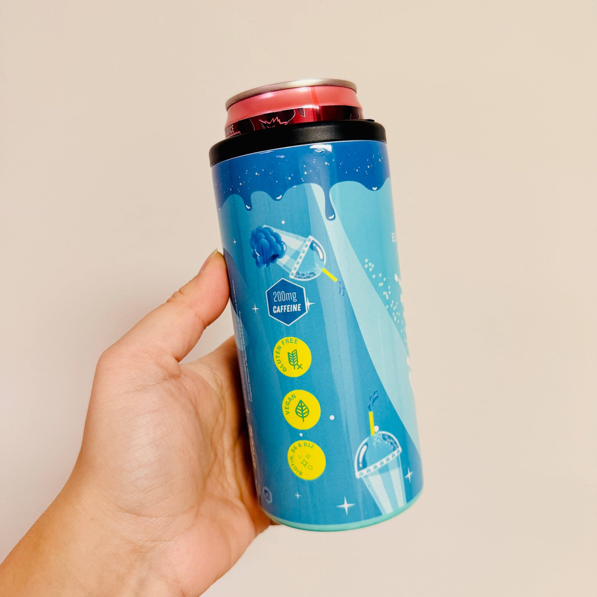Hand holding a blue can with a design on a beige background