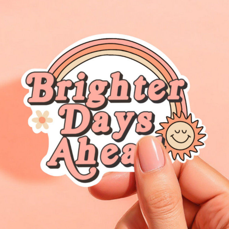 a sticker with a rainbow and smiling sun that reads brighter days ahead
