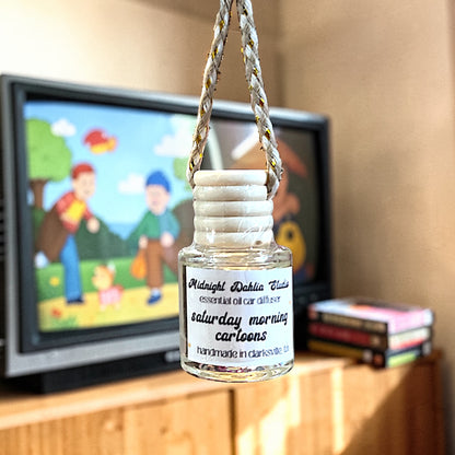 Small bottle with a label on a rope in front of a television displaying children's content.