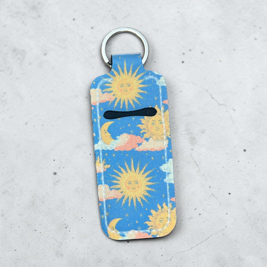 Keychain with sun and cloud pattern on a light gray background