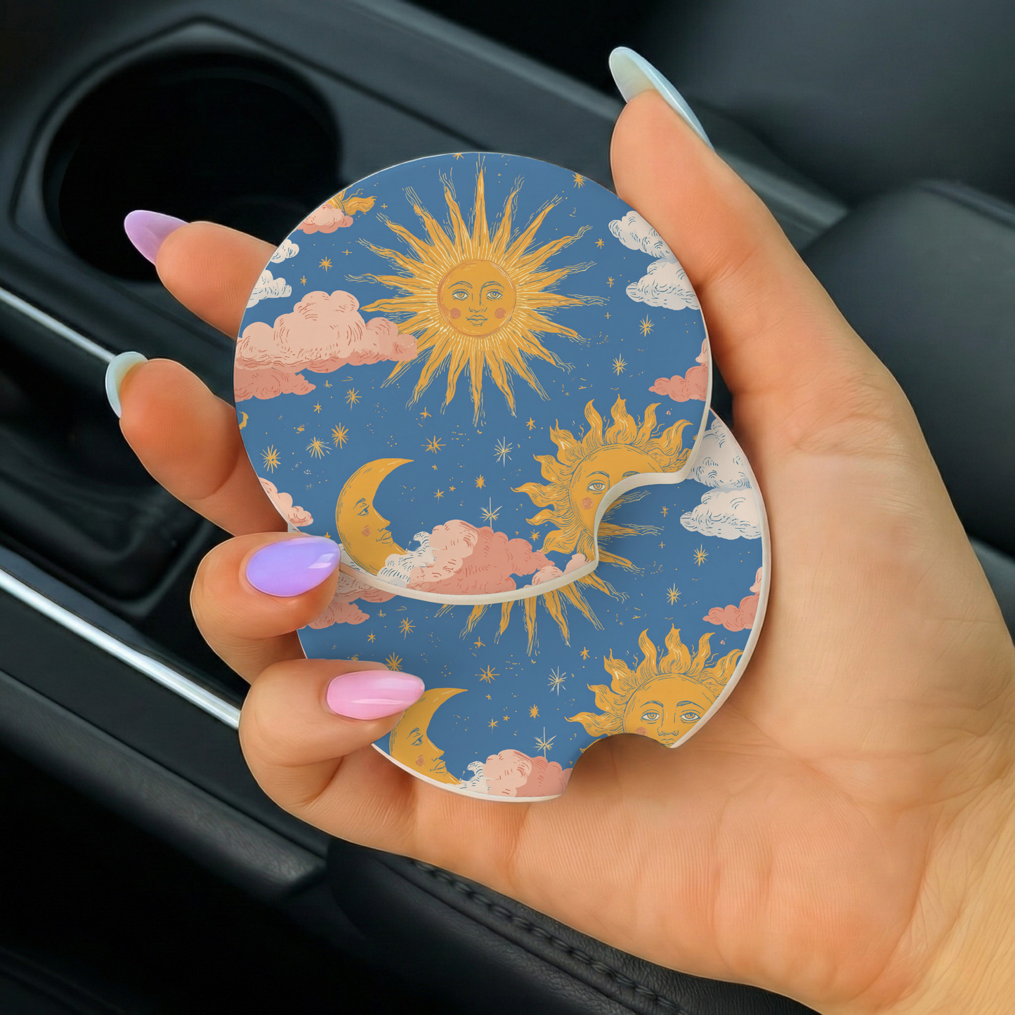 Hand holding a car coaster with sun and cloud design