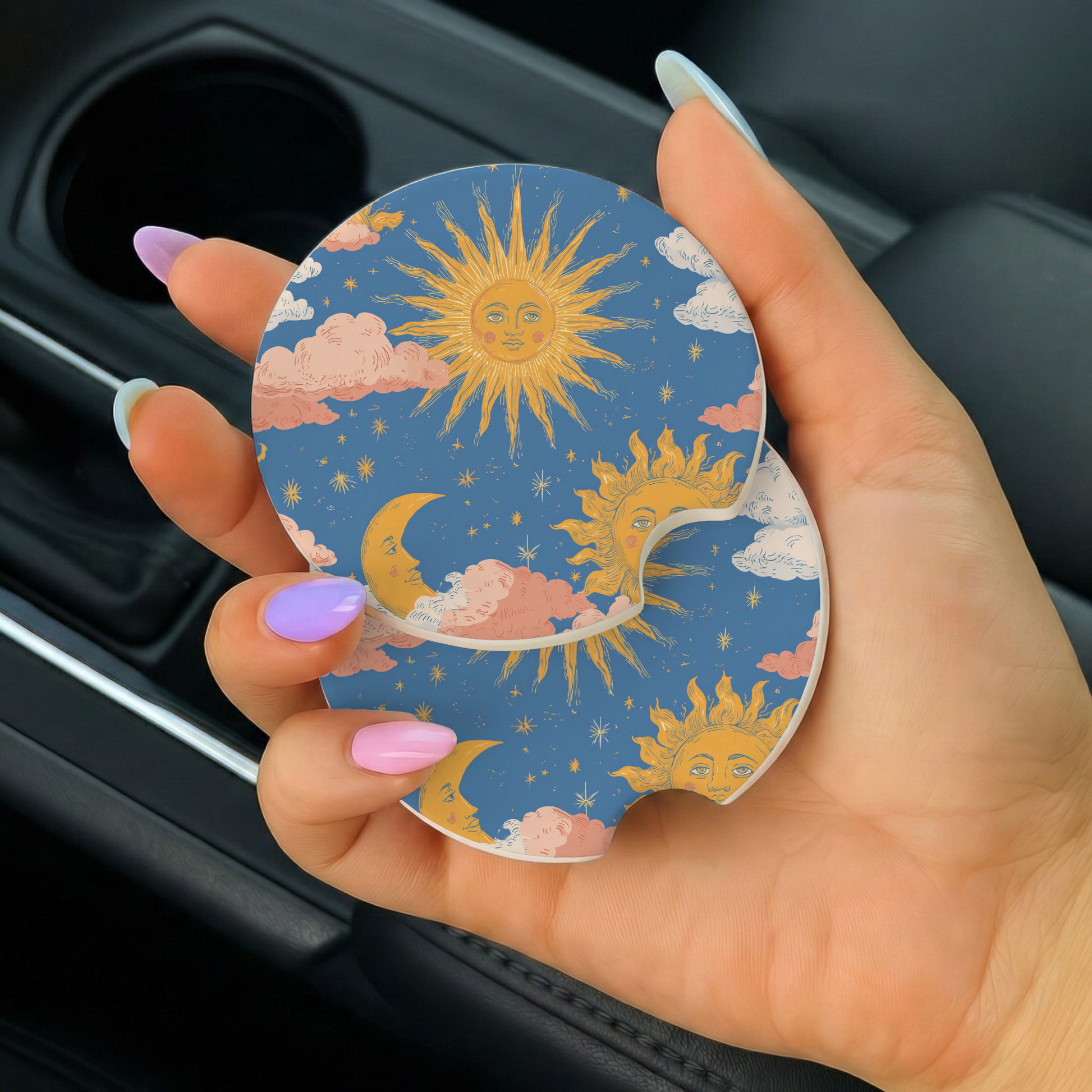 Hand holding a car coaster with sun and cloud design
