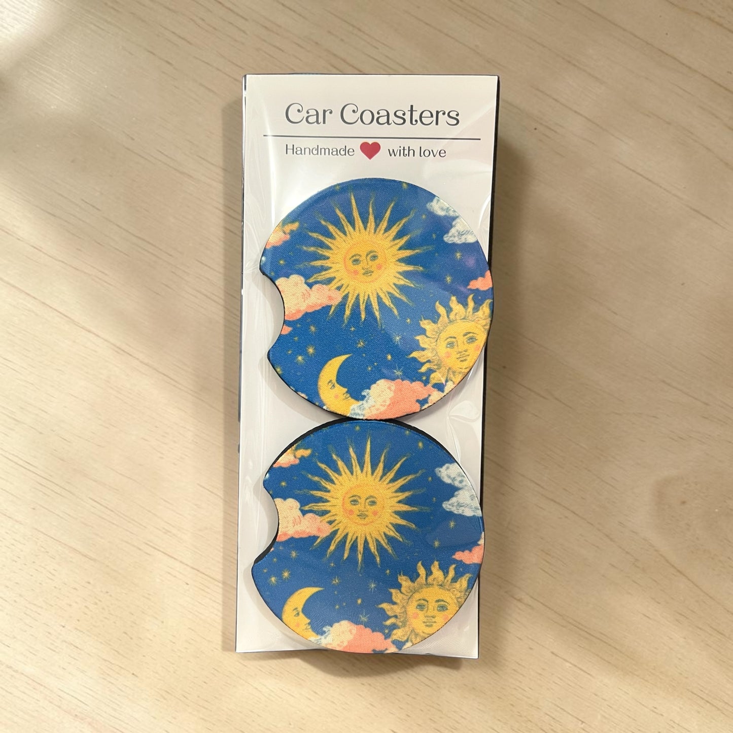 Pack of car coasters with sun and moon design on a wooden surface