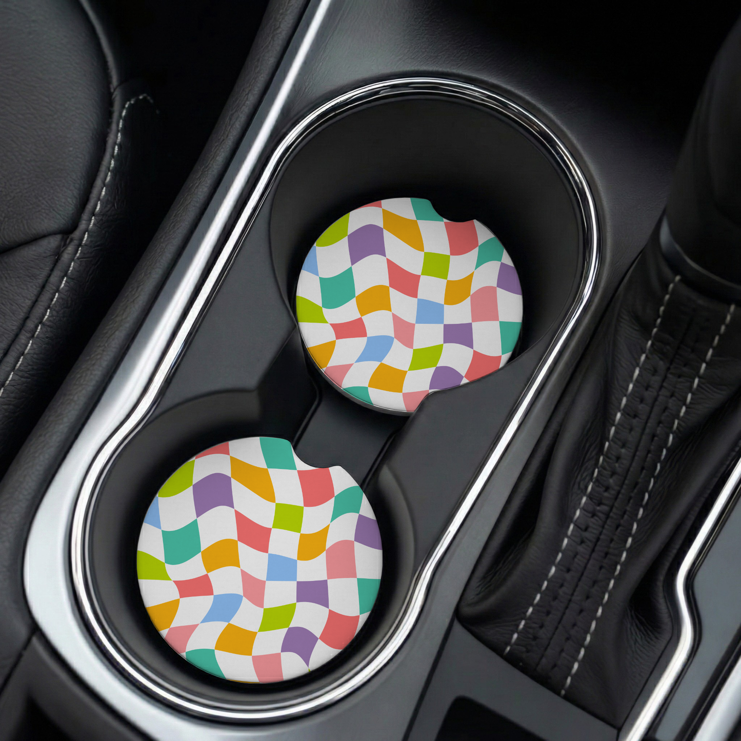 Two colorful checkered car cup holders in a vehicle's cup holder.