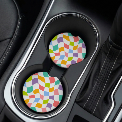 Two colorful checkered car cup holders in a vehicle's cup holder.