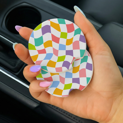 Colorful checkered car coaster held by a hand in a car.