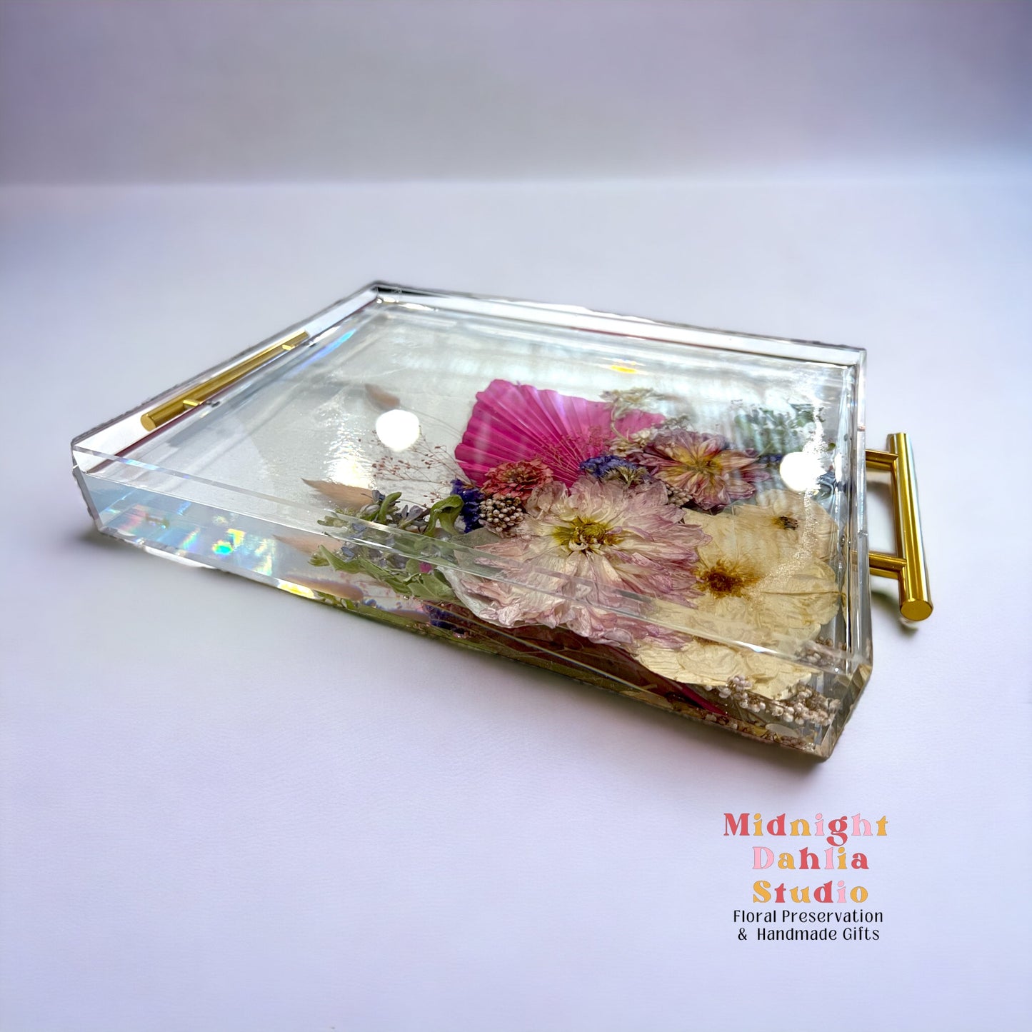 A custom acrylic tray filled with bright flowers including a peony and roses and crystal clear resin.  A beautiful way to preserve a bridal bouquet.