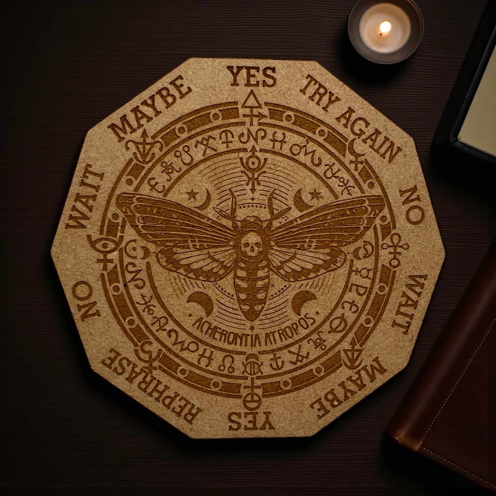 Decorative coaster with a moth design and text on a wooden surface.