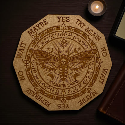 Decorative coaster with a moth design and text on a wooden surface.