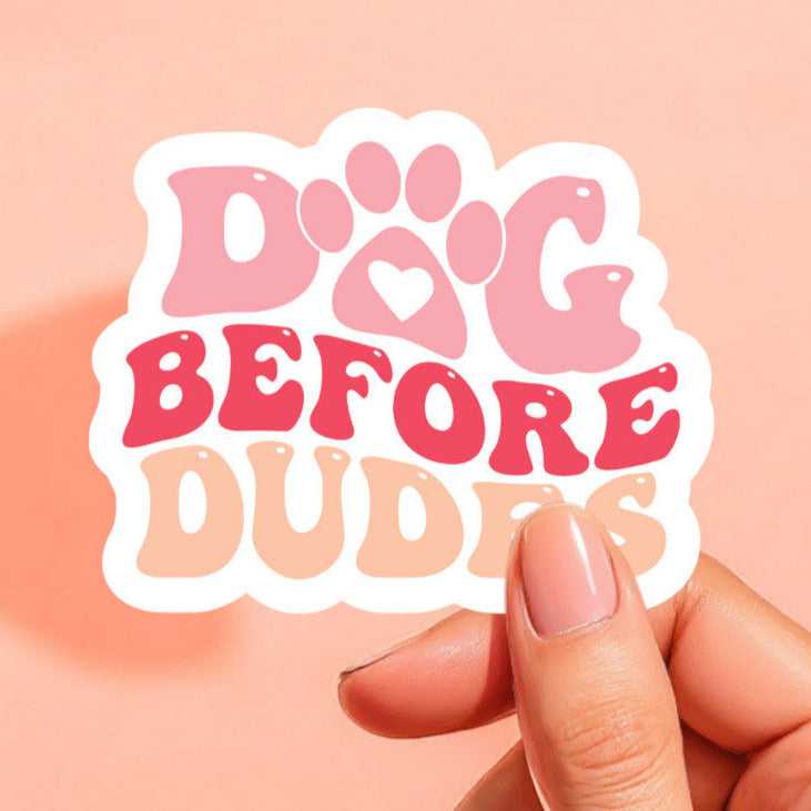 a white background sticker with dog before dudes printed in light pale pink, bright reddish pink, and a peach orange color