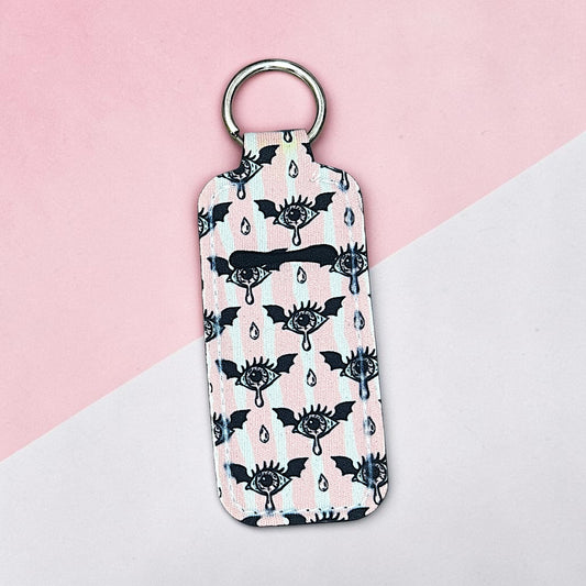 Keychain with black and white pattern on a pink and gray background