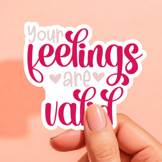 a white sticker that reads your feelings are valid in hot pink