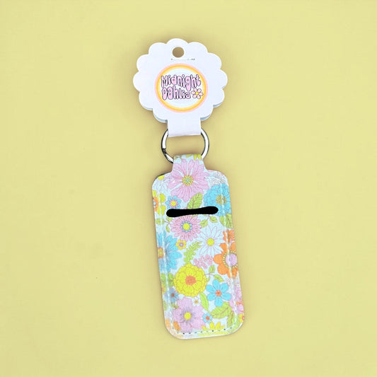 Floral-patterned keychain with a brand tag on a yellow background
