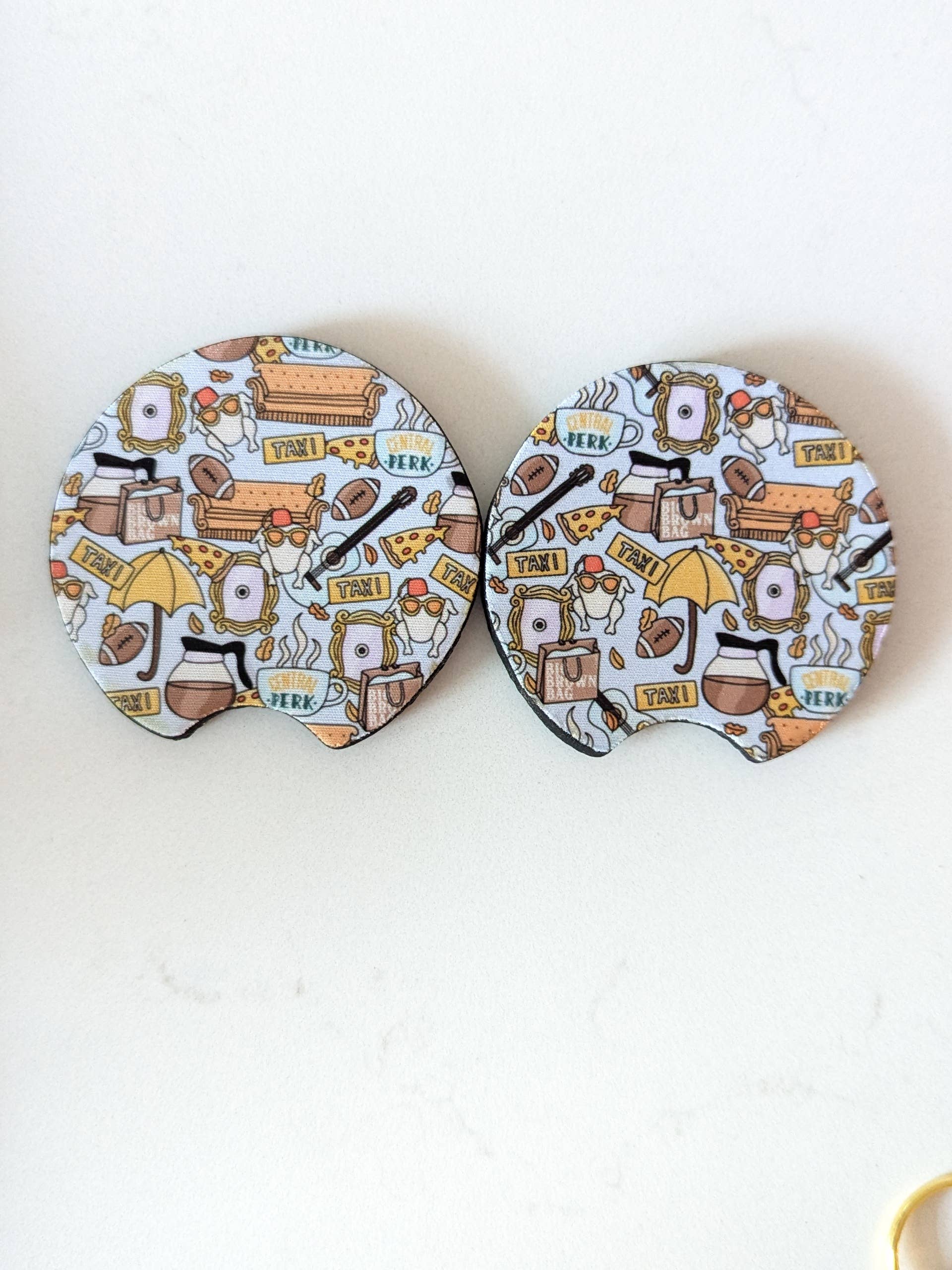 Two round coasters with a cartoon-themed design on a white background