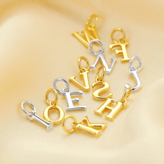 Gold and silver letter pendants on a gold background