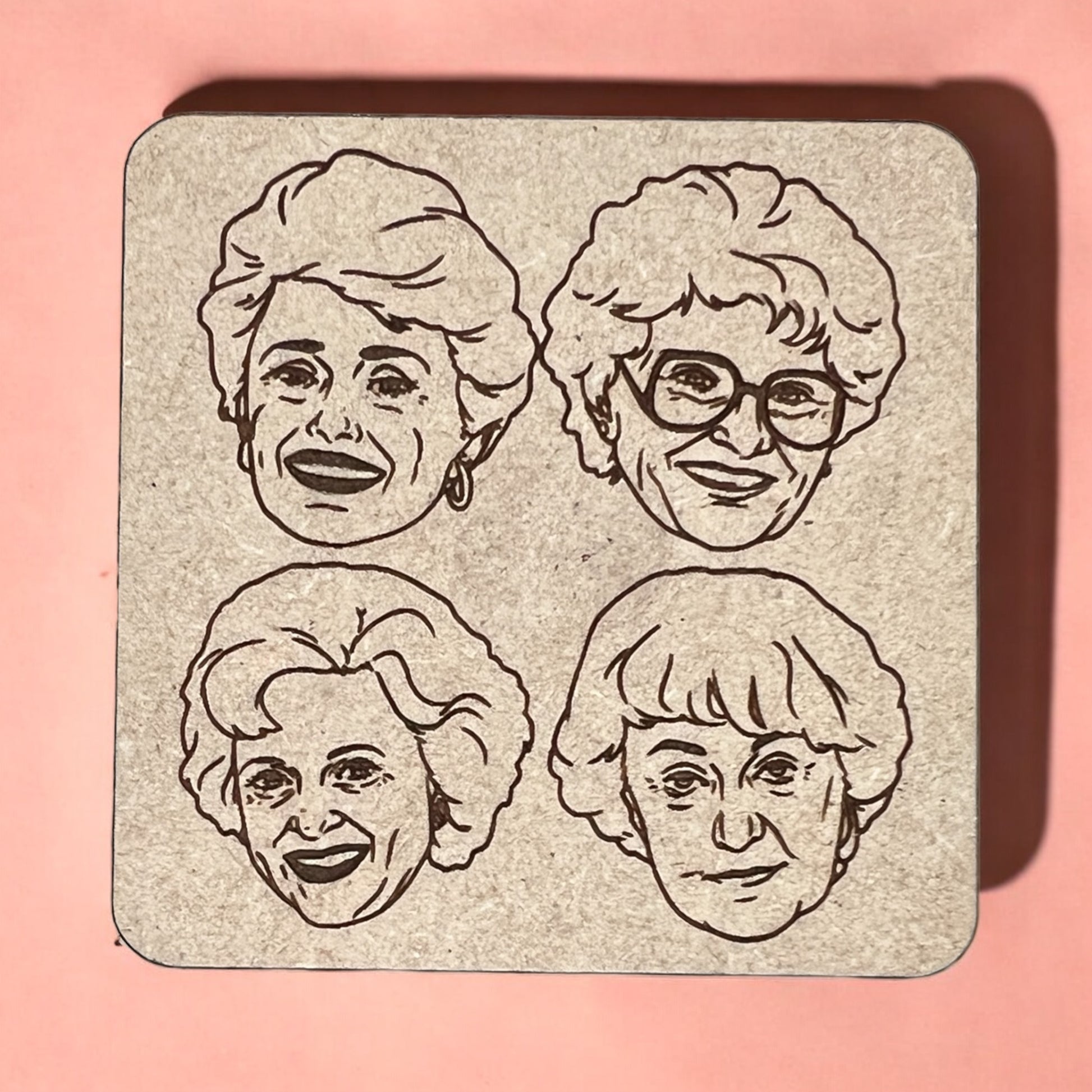 A square magnet with a humorous quote printed on it, placed against a pink background.