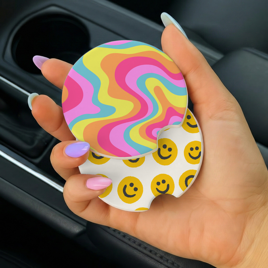 Hand holding a colorful car coaster with smiley face pattern
