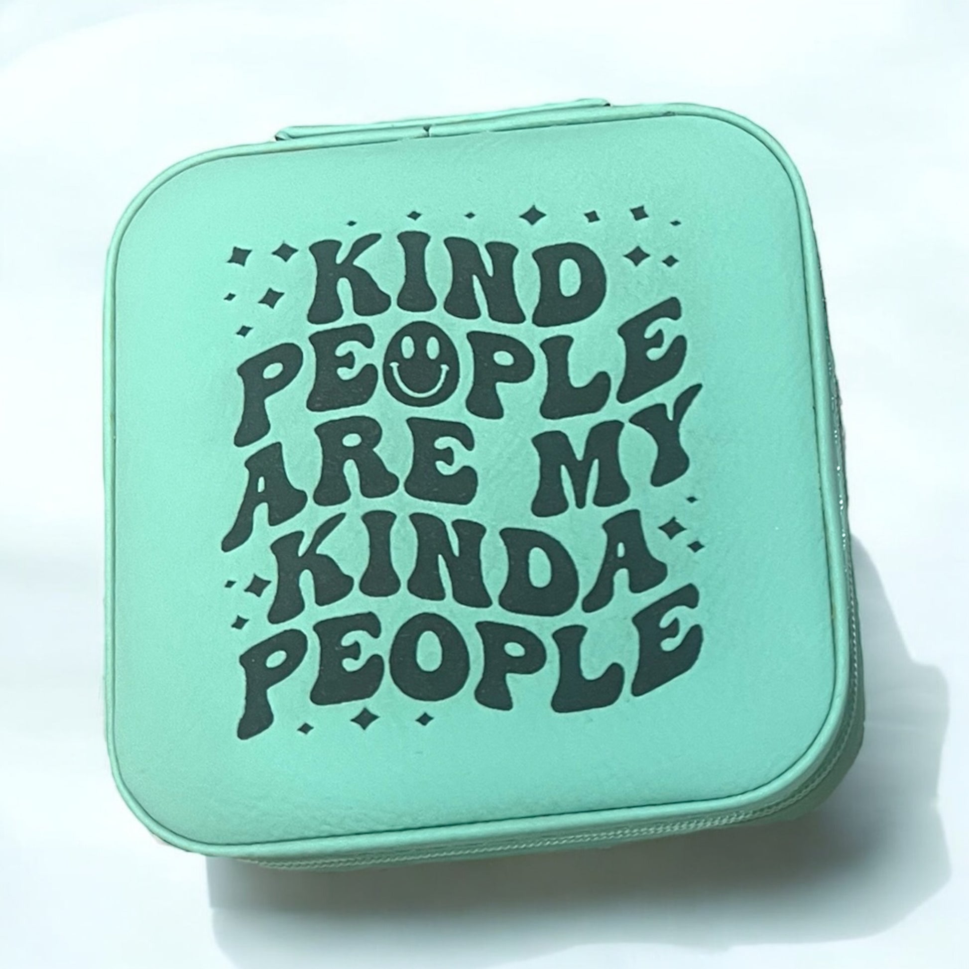 a teal jewelry box engraved with words in black that read kind people are my kinda people