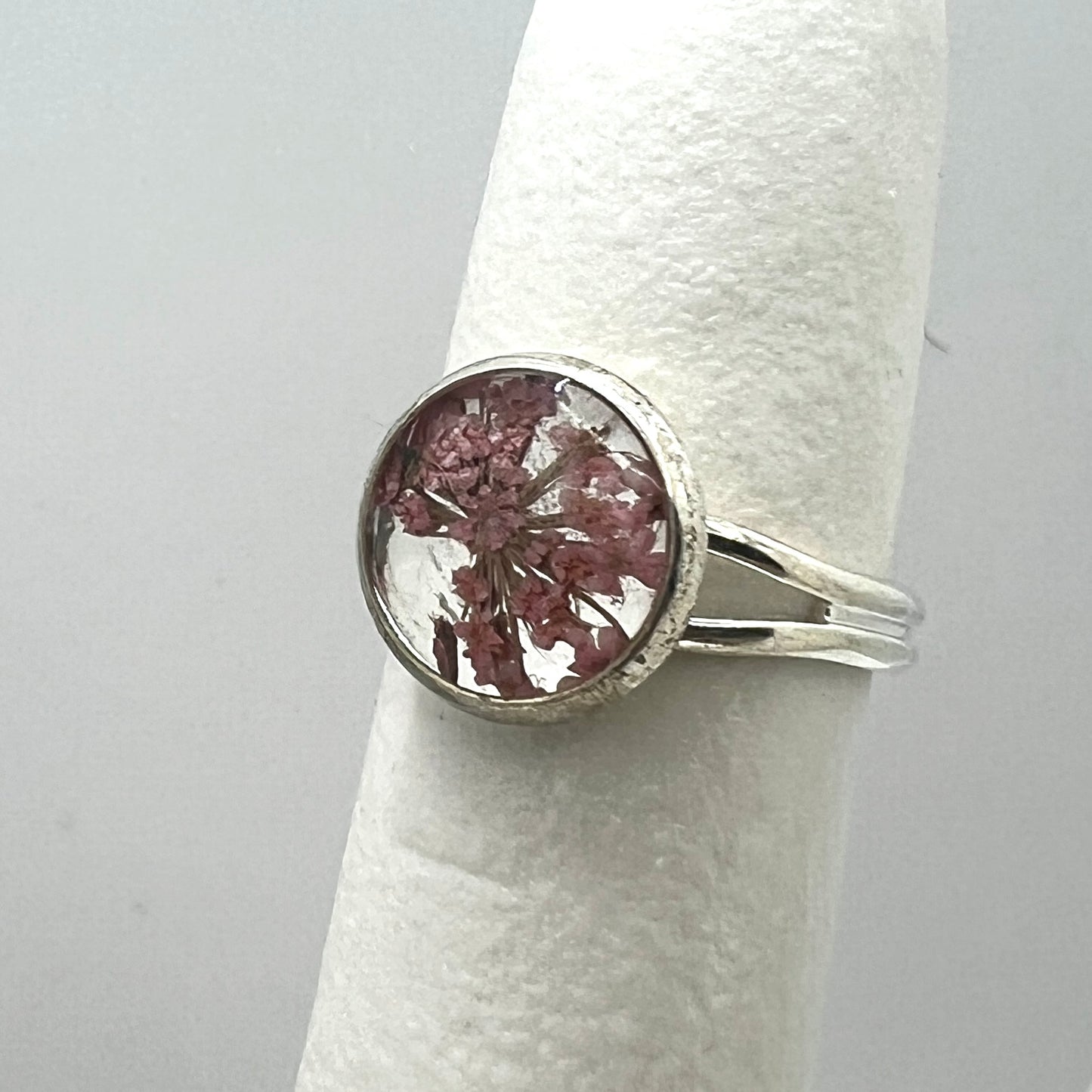 Silver ring with a floral design on a white background