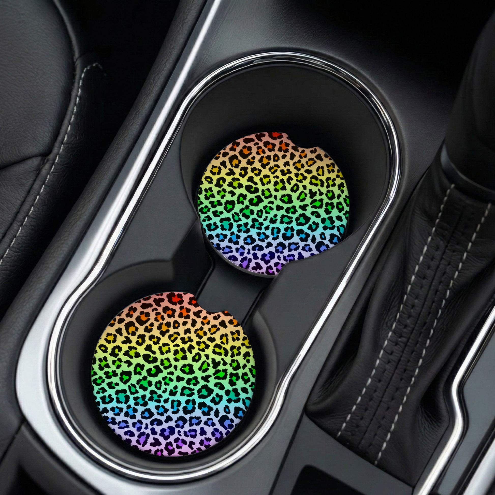 Two rainbow leopard print coasters in a car cup holder.