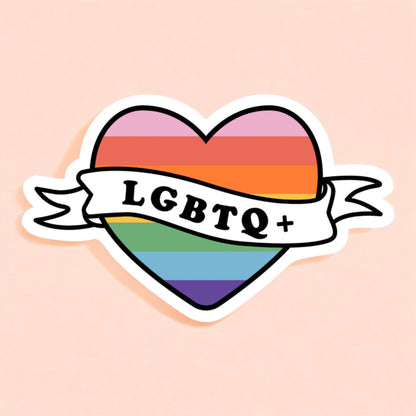 a heart shaped sticker printed with a rainbow with a banner that reads lgbtq+