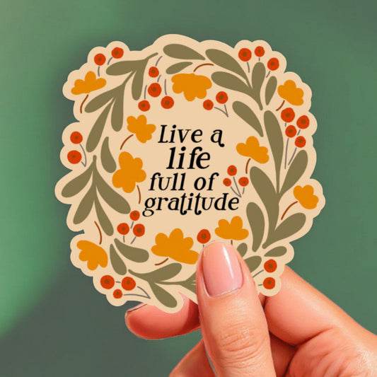 a sticker with a light mustard yellow background that reads live a life full of gratitude surrounded by flowers
