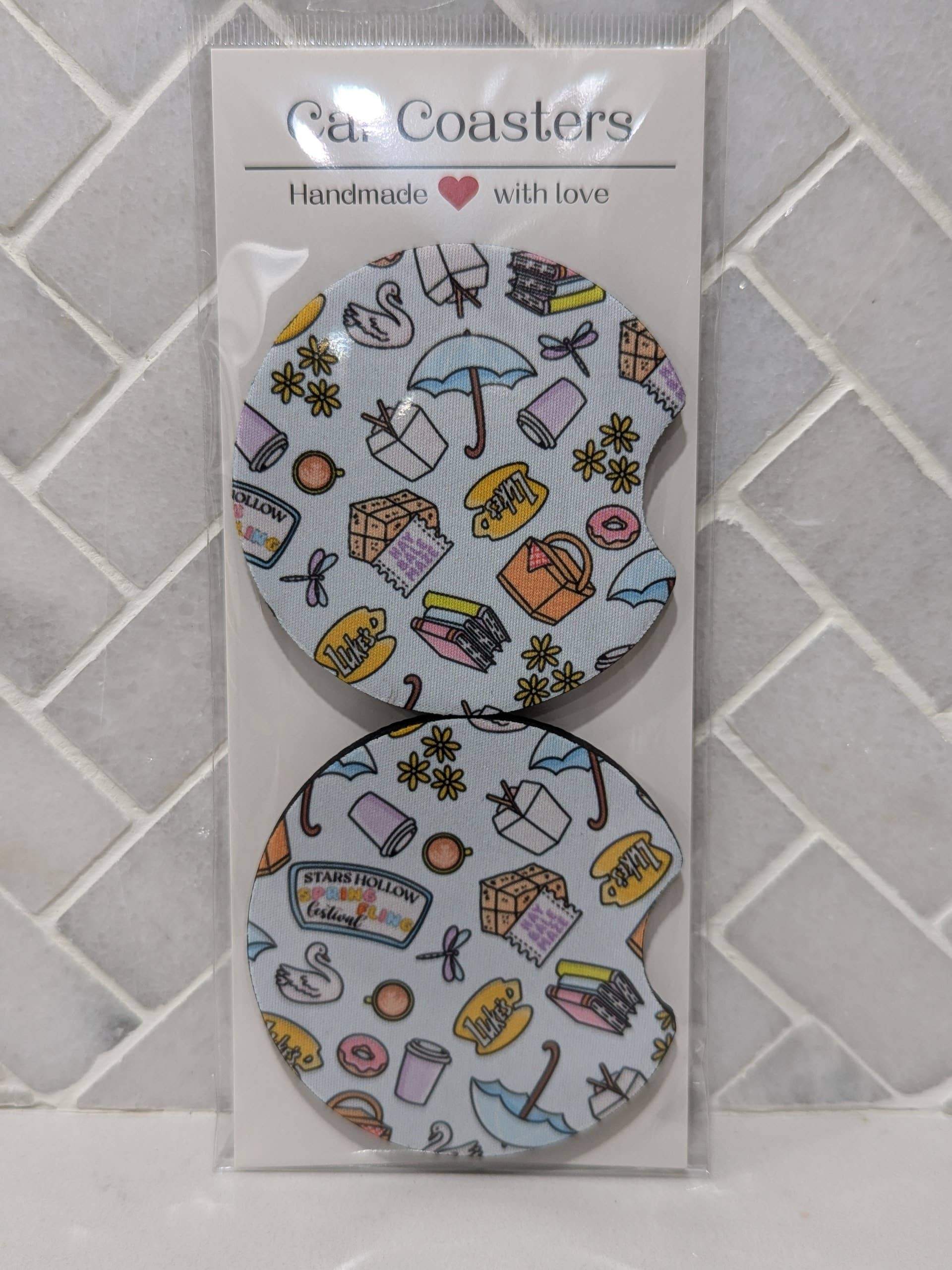 Packaged set of coasters with various illustrations on a tiled background