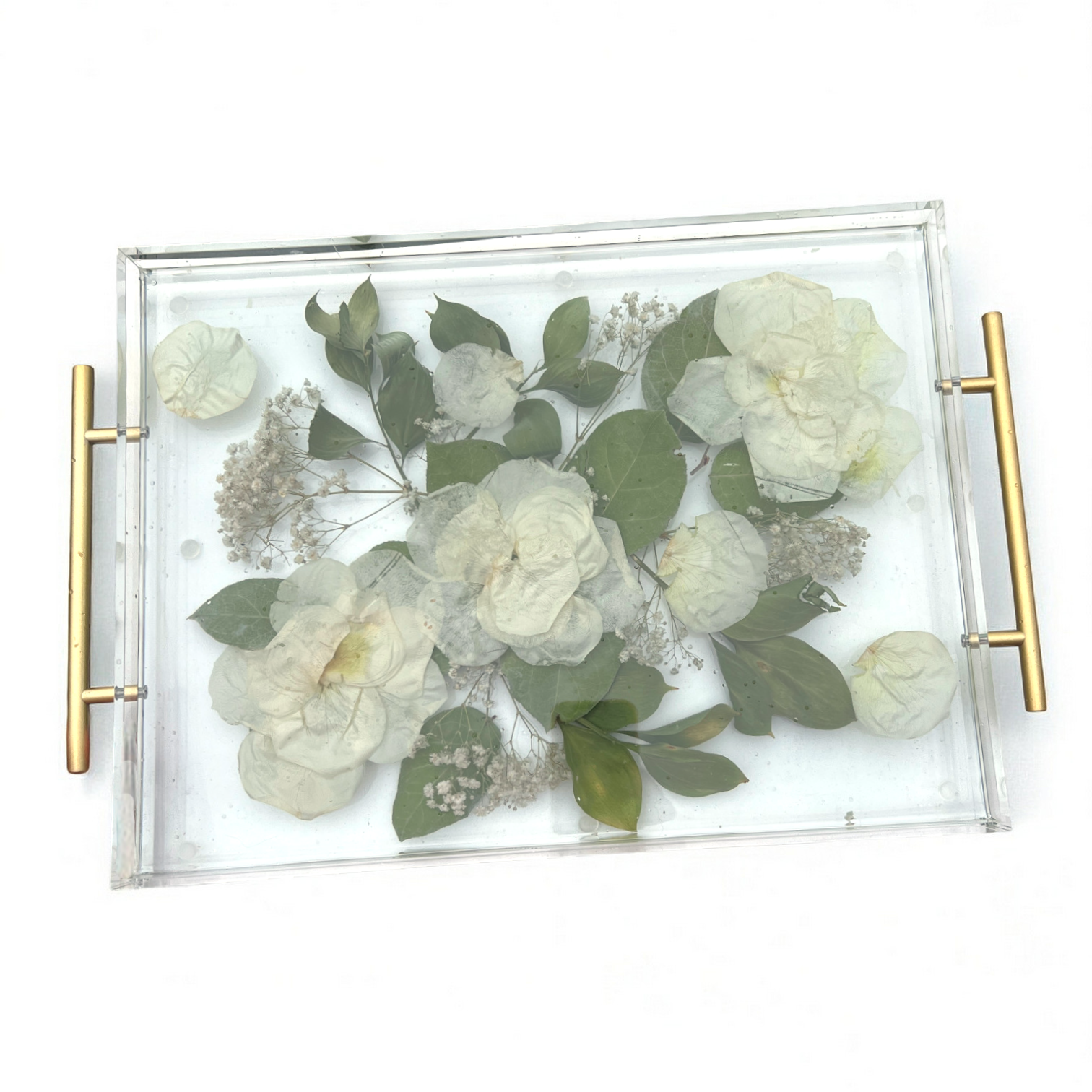 Decorative tray with pressed flowers and greenery on a white background