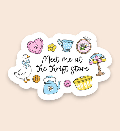 Sticker with various illustrations and text 'Meet me at the thrift store' on a beige background