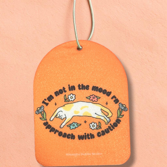 Orange tag with a cat illustration and text on a peach background