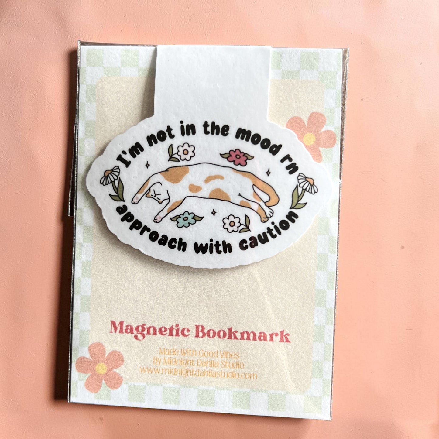 Magnetic bookmark with dog illustration and text on a checkered background