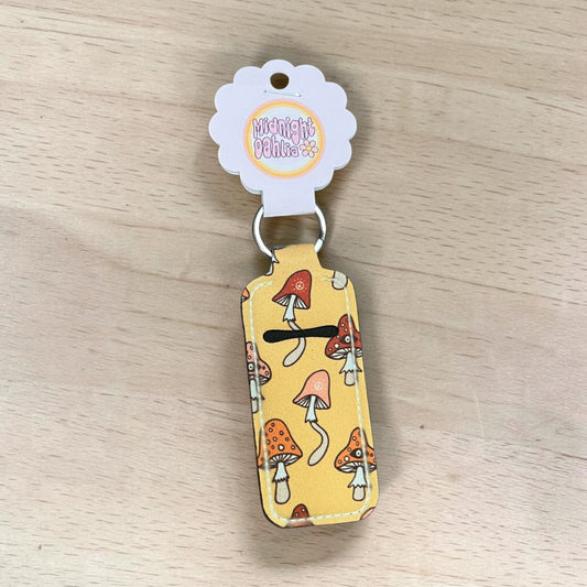 lip balm keychain with mushroom design on a wooden surface