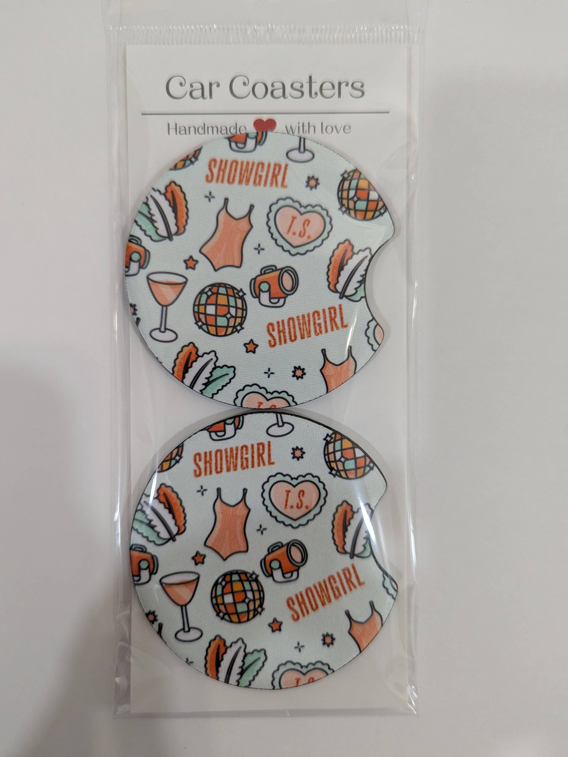 Two car coasters with 'Showgirl' design in packaging on a white background