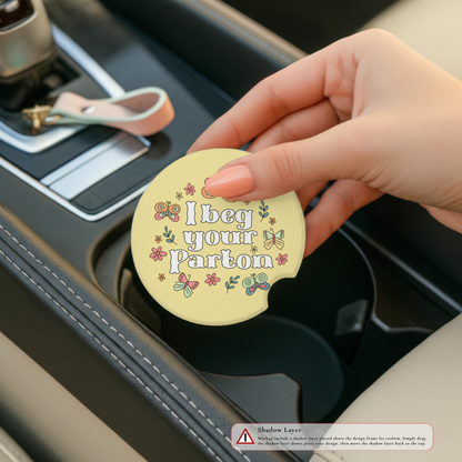 Hand holding a car coaster with humorous text design in a car's cup holder.