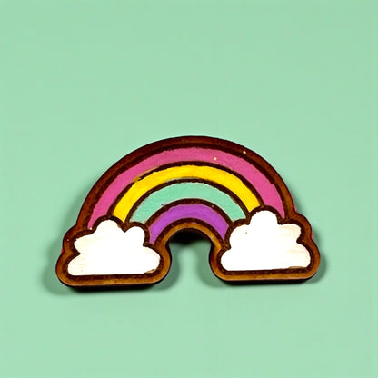 Rainbow-shaped cookie with white clouds on a light green background