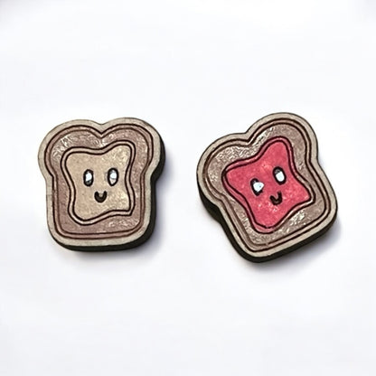 Two cute toast-shaped earrings with smiling faces on a white background