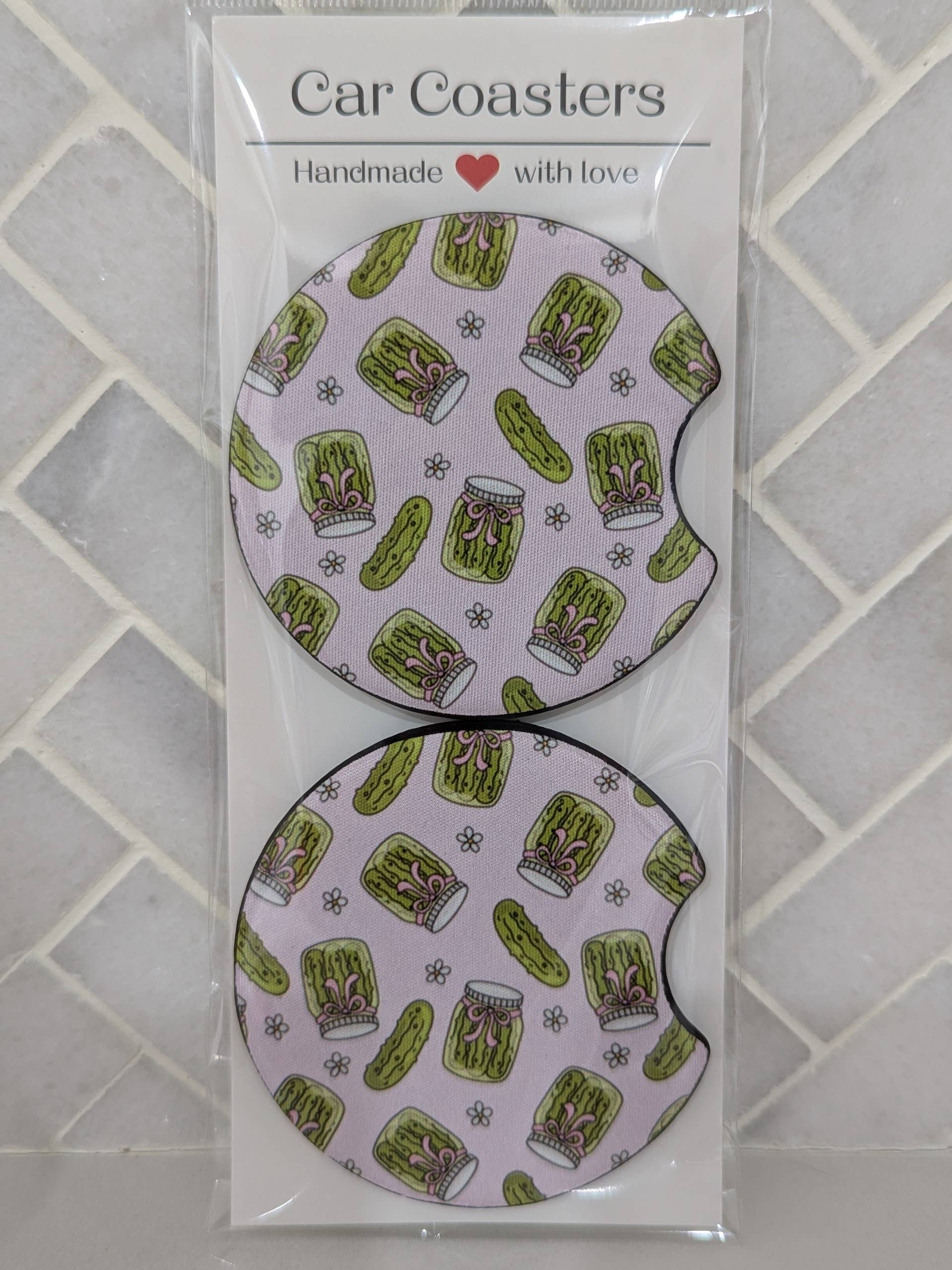 Car coasters with pickle pattern in packaging on a tiled surface