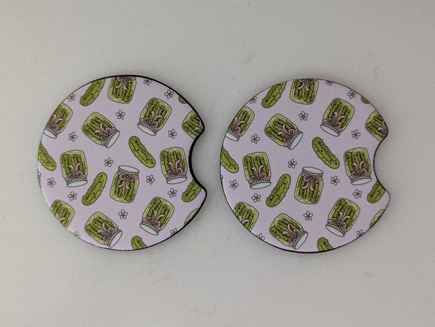 Two round coasters with a green and white pattern on a white background
