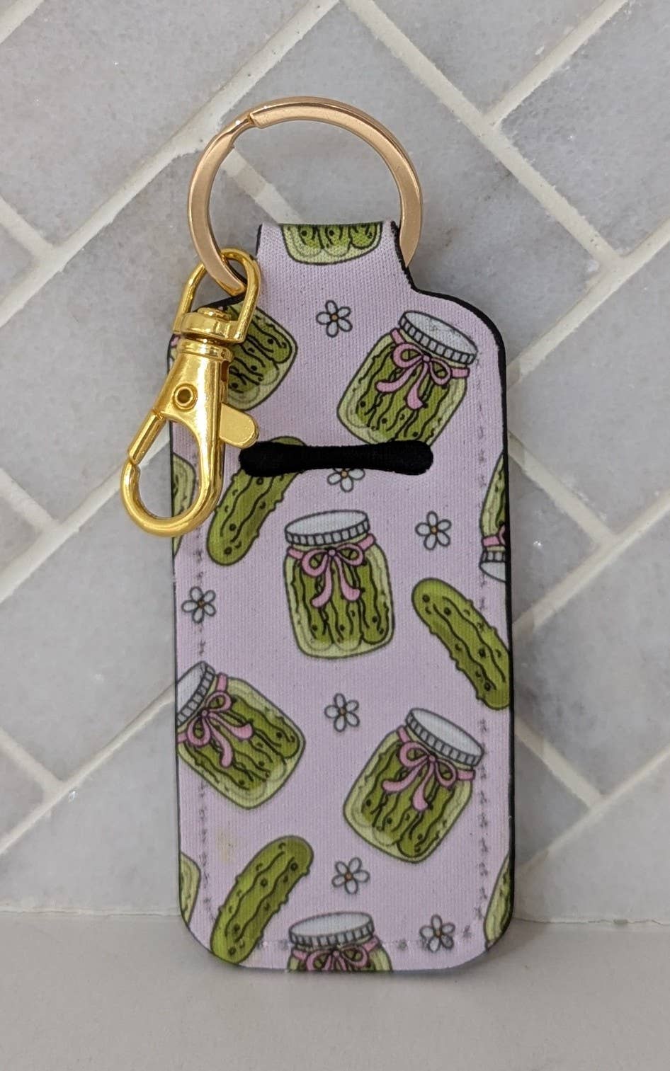 Keychain with pickle pattern on a light purple background