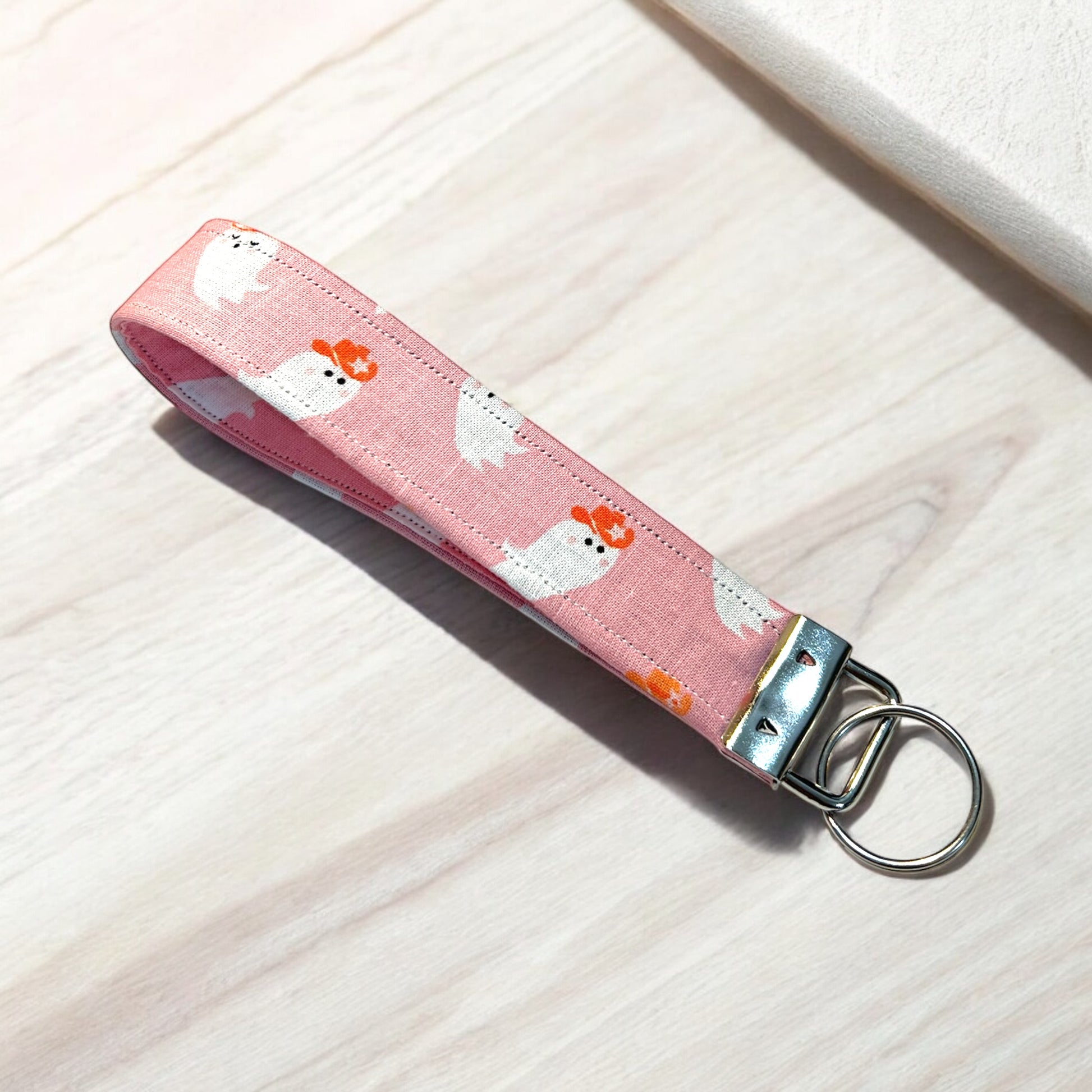 a handmade fabric wristlet keychain key chain against a pastel background