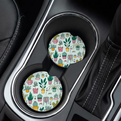 Two car coasters with plant pattern in a cup holder.