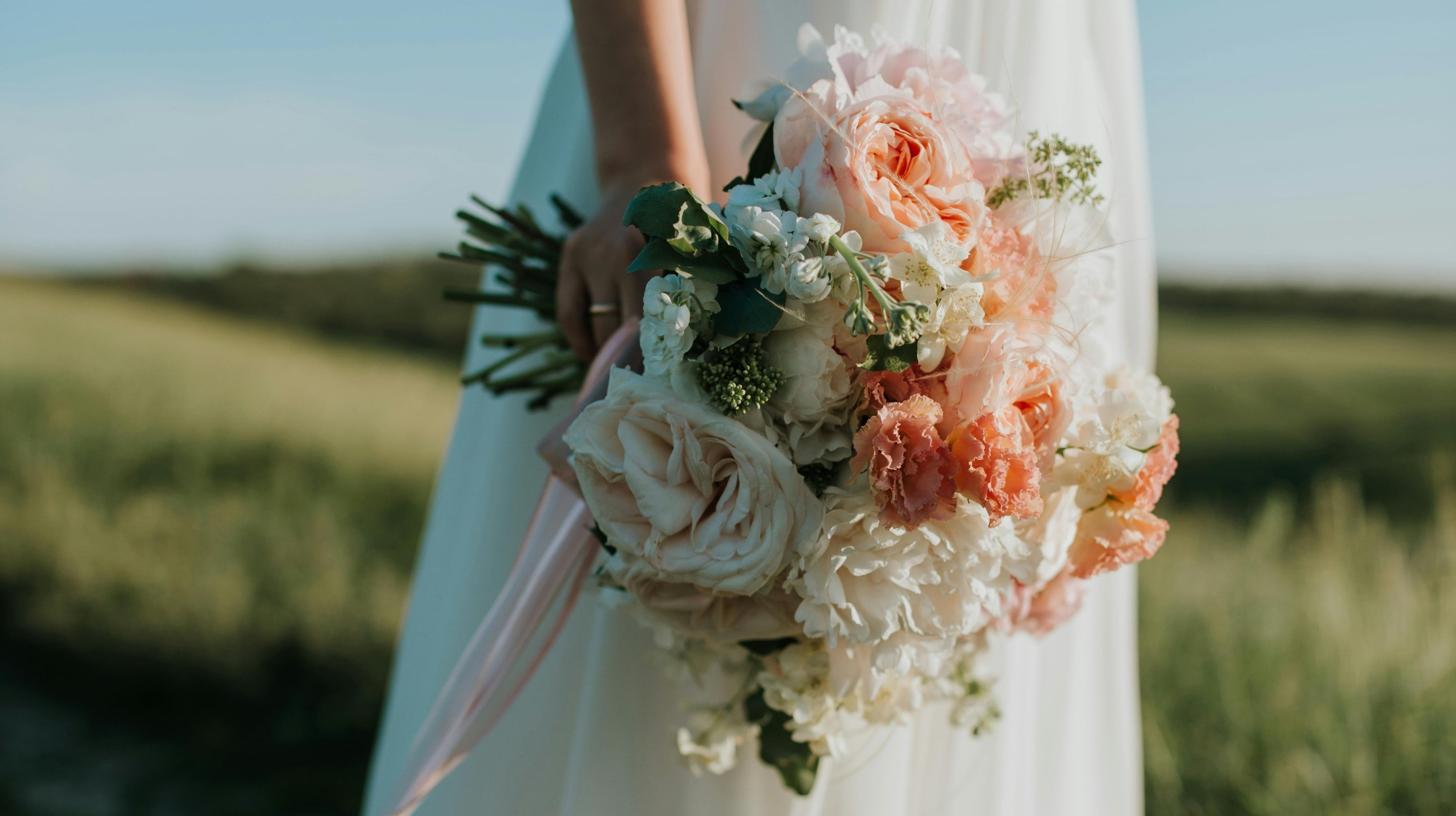 Bride holding a bouquet of flowers in a field