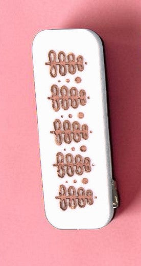 White rectangular object with decorative patterns on a pink background