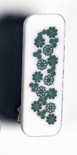 White hair clip with green floral patterns on a white background
